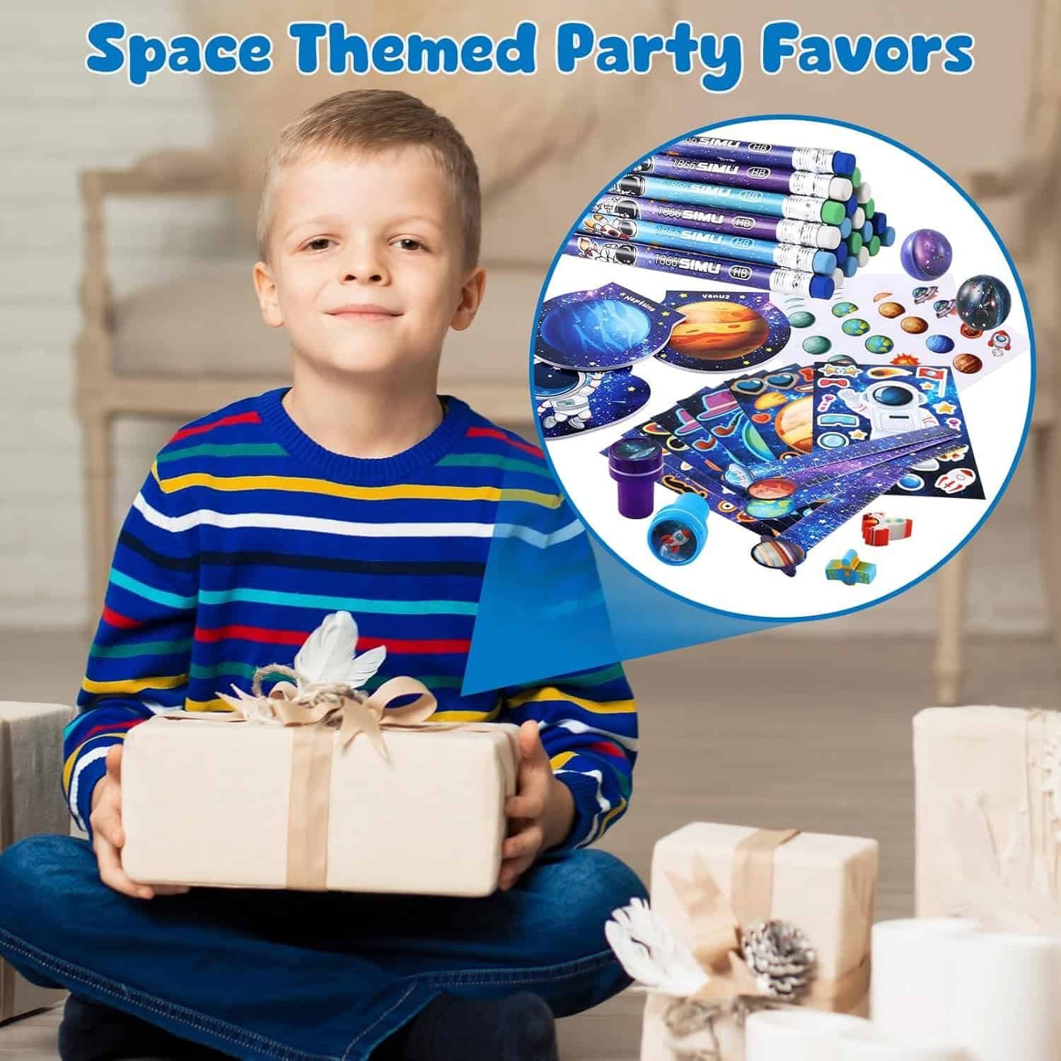 A boy in a striped sweater holds a wrapped gift. An inset shows various space-themed party favors, including stickers, pencils, and erasers.
