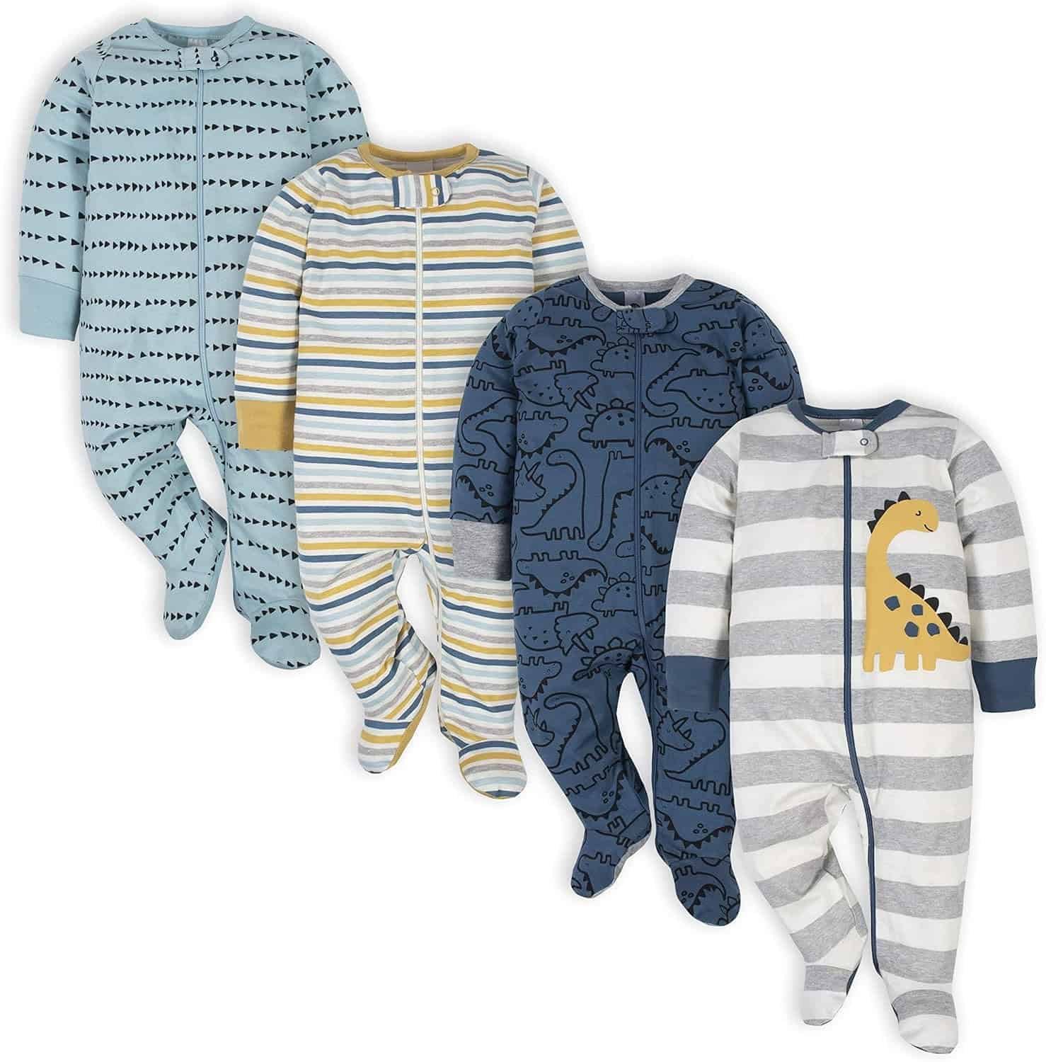 Four baby onesies with feet arranged side by side, featuring different patterns: blue with dots, striped, blue with dinosaur outlines, and gray striped with a yellow dinosaur graphic.