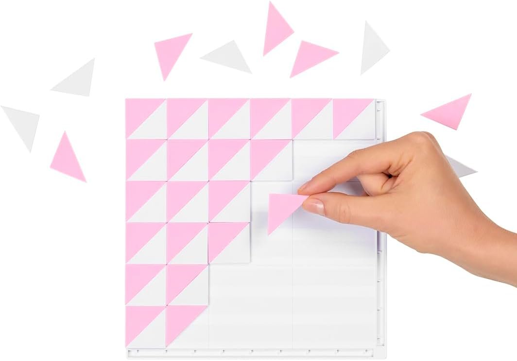 A hand places a pink triangle tile onto a white grid, completing a geometric pattern with pink and white triangles.