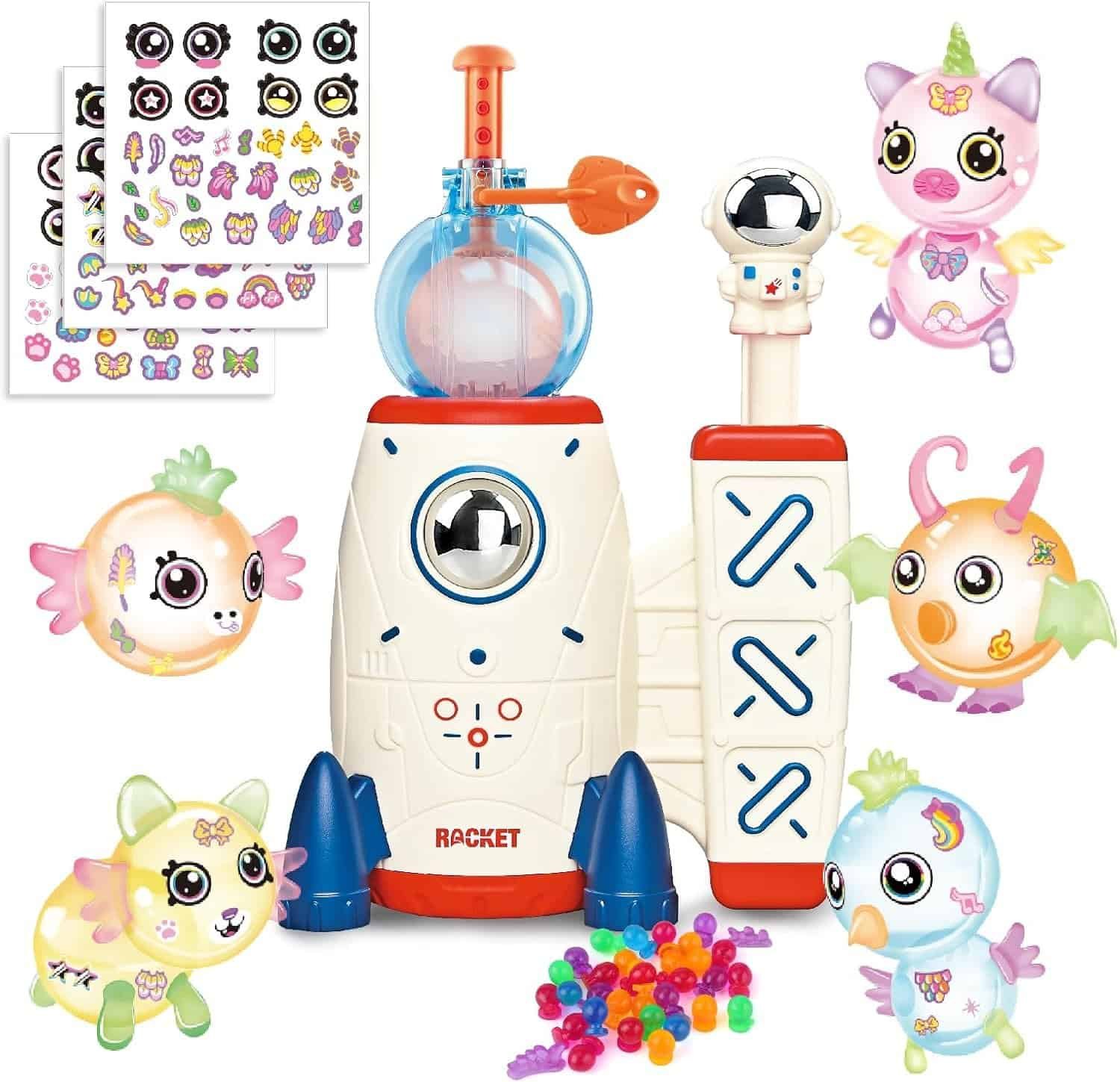 Children’s rocket playset with colorful toy animals, stickers, and beads arranged around a white rocket ship and accessories.