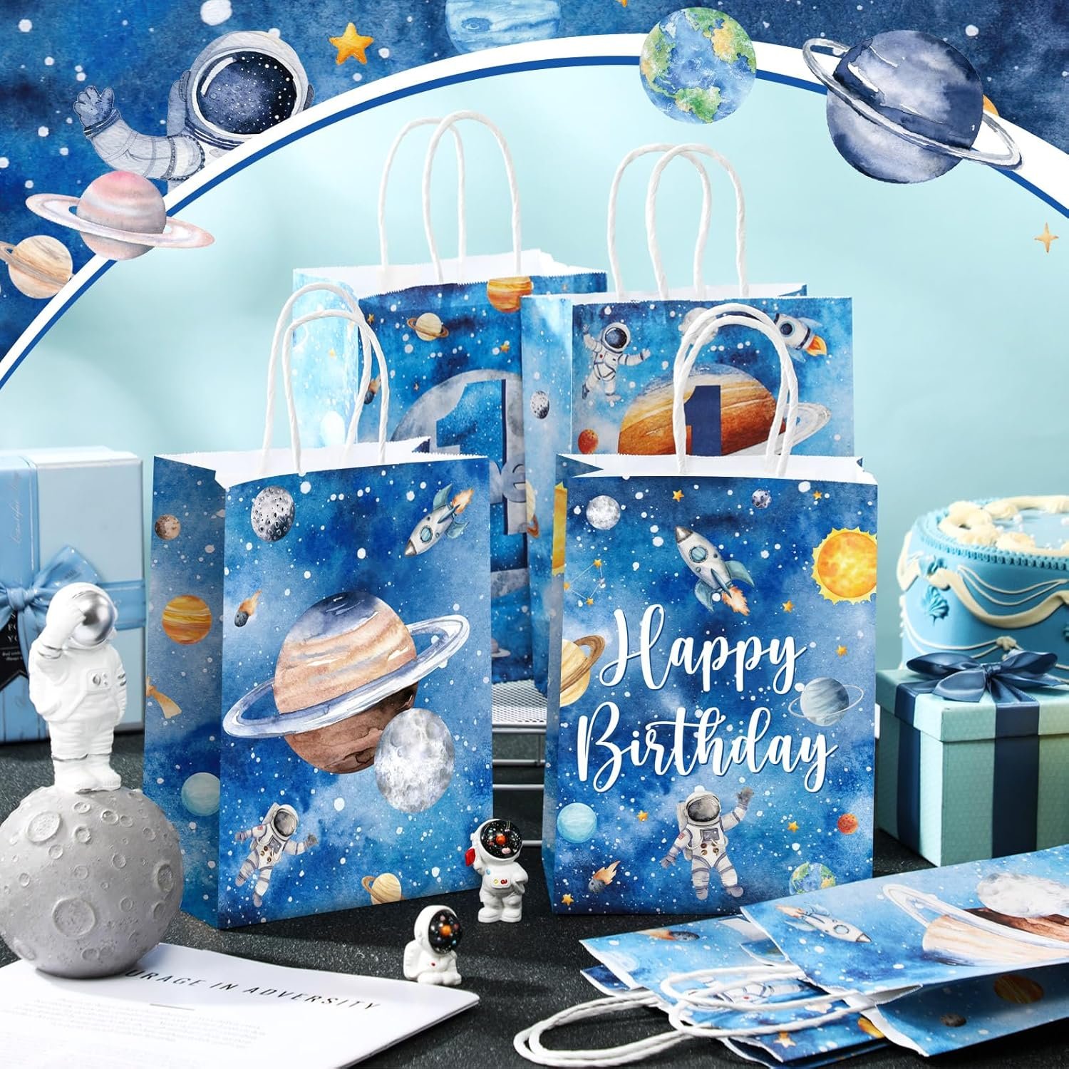 Gift bags with a space theme, featuring planets, astronauts, and rockets, are displayed on a table with birthday gifts and decorations. One bag reads "Happy Birthday.
