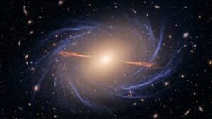 A bright galaxy at the center emits light, with spiral arms and numerous smaller galaxies, red geyser galaxies, and stars scattered throughout the dark space background.