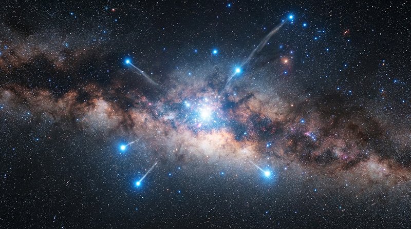 A dense region of the Milky Way galaxy is shown with bright blue stars and streams of stars radiating outward against a dark, star-filled background.