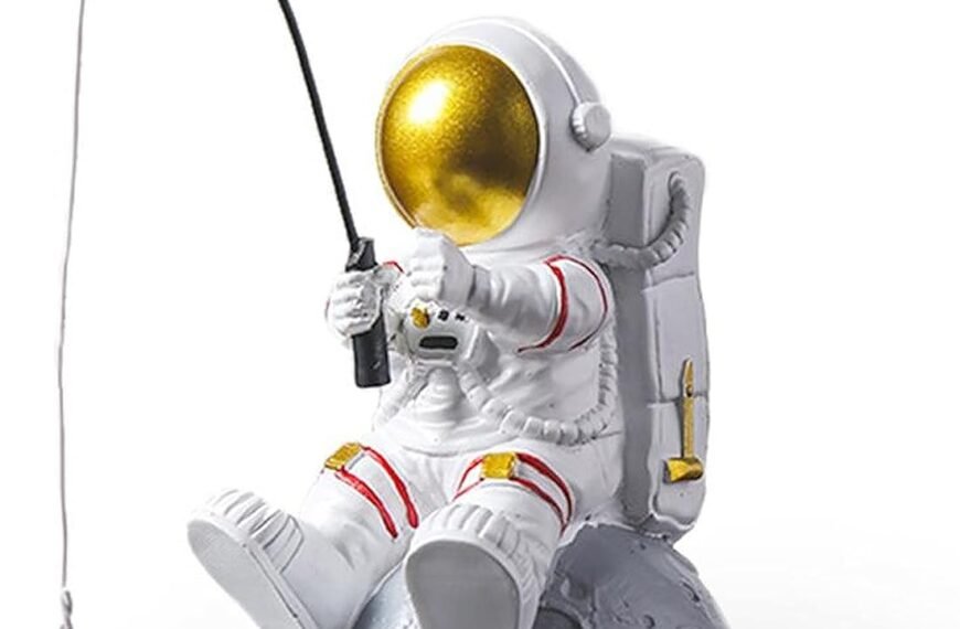 A figurine of an astronaut sitting on a small moon, holding a fishing pole with a dangling gold star attached to the line.