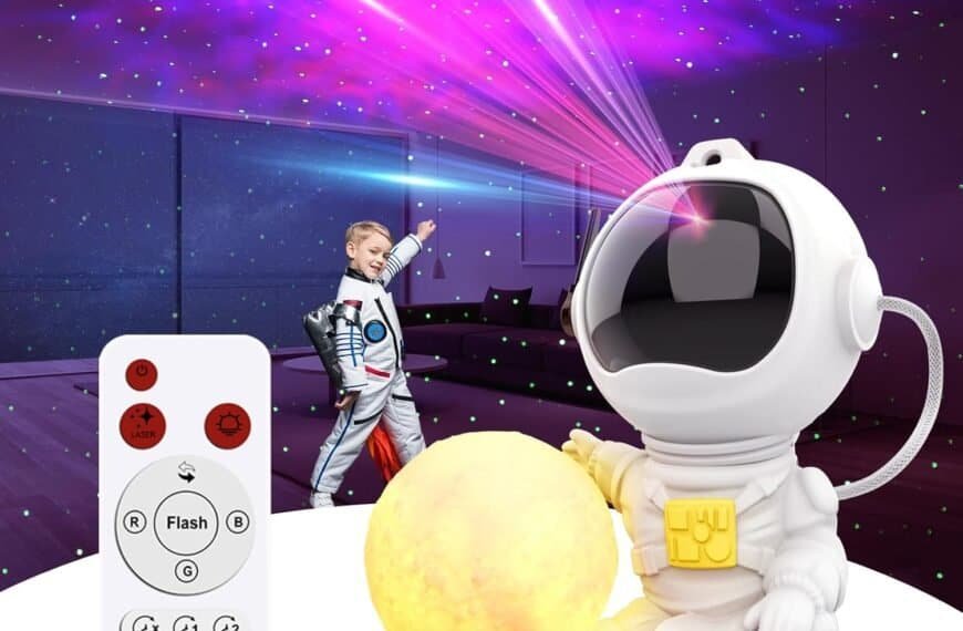 A child in an astronaut costume stands in a room with starry laser projections, next to an astronaut-themed night light and a remote control.