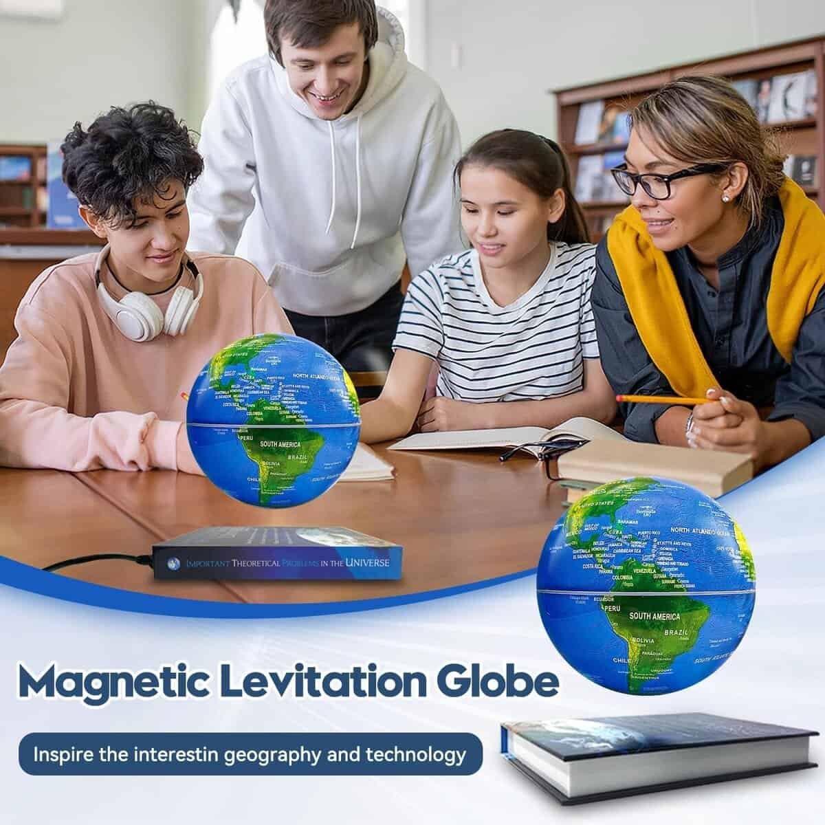 Three people sit at a table in a library, observing a blue and green magnetic levitation globe floating above a book.