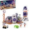 LEGO Friends Space set with a habitat module, rocket, rover, two astronaut mini-figures, a green alien figure, and the packaging box shown in the background.