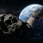 A large asteroid floats in space near Earth, with the planet's continents and city lights visible against a starry background in this stunning NASA image.