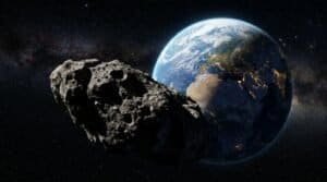 A large asteroid floats in space near Earth, with the planet's continents and city lights visible against a starry background in this stunning NASA image.