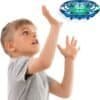 A young boy in a gray shirt raises his hands toward a flying blue drone hovering above him against a white background.