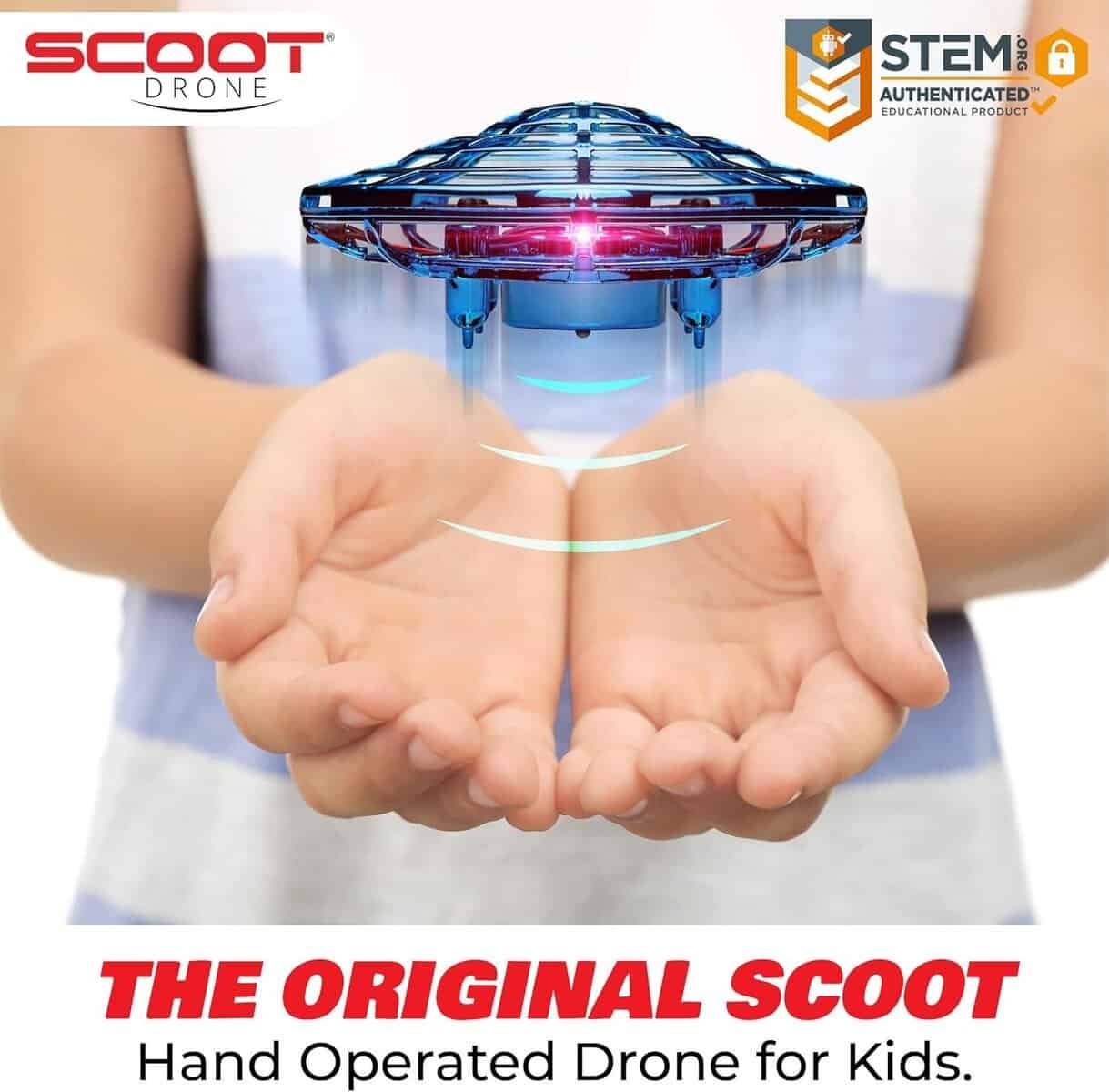 A person holds out their hands below a hovering blue toy drone. Text reads: "The Original Scoot. Hand Operated Drone for Kids." STEM authentication logo is visible.
