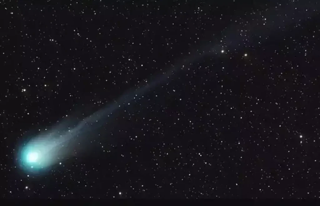 A comet with a glowing nucleus and a tail against a starry night sky, now known as the Mother of Dragons Comet, presents a cosmic spectacle.