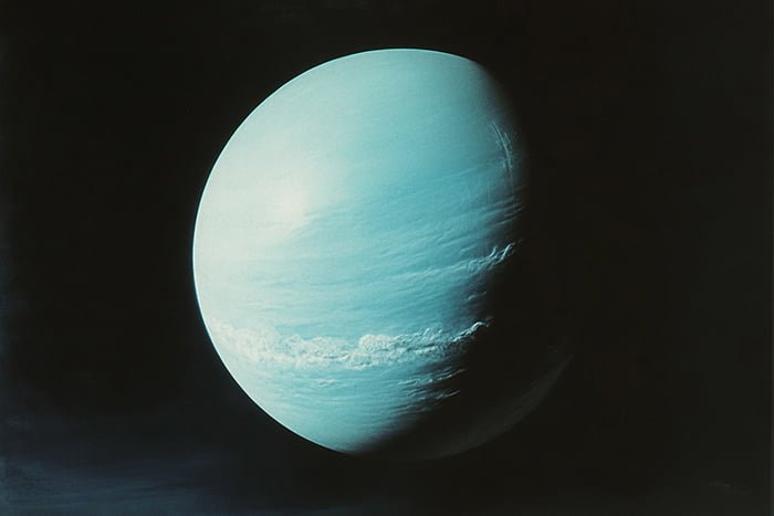 Unveiling the Enigmatic Planet Uranus: Exploring Its Unique Features and Captivating History 1 An image of a blue-green planet resembling Uranus is set against a dark background, revealing intricate cloud formations and atmospheric bands.