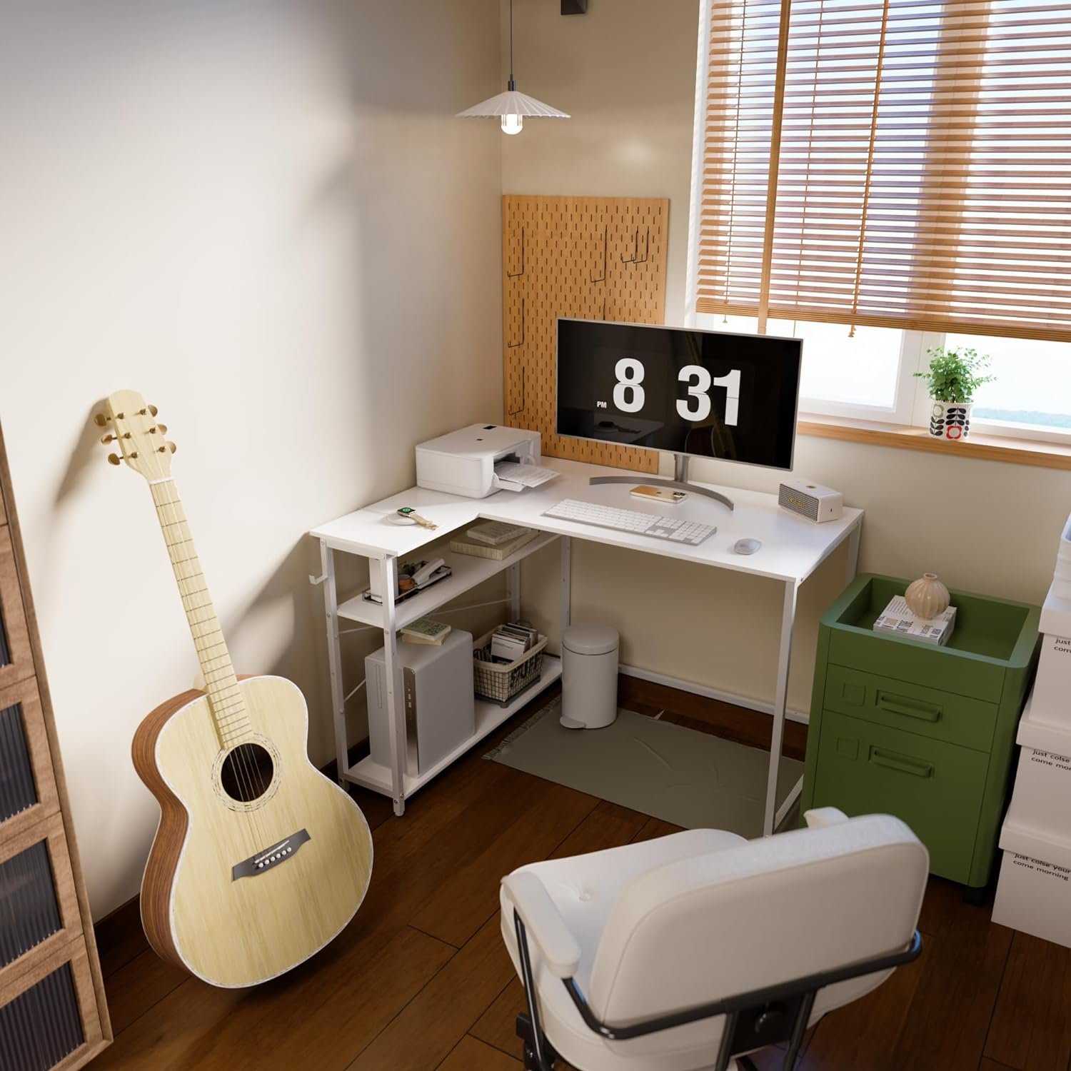 A small home office features a white desk with a computer, printer, and some accessories. A guitar leans against the wall, and a green filing cabinet is nearby. A window with blinds is in the background.