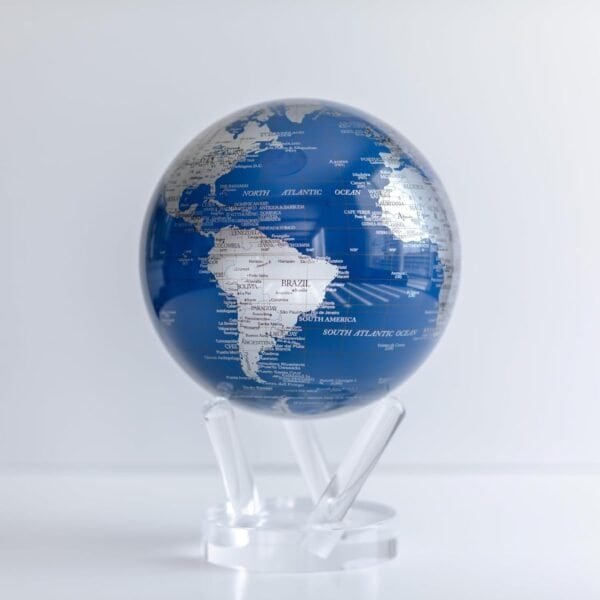 The Globe Metallic 4.5" elegantly features parts of South America and the Atlantic Ocean, adorned in a striking blue and white design and perched on a clear stand.