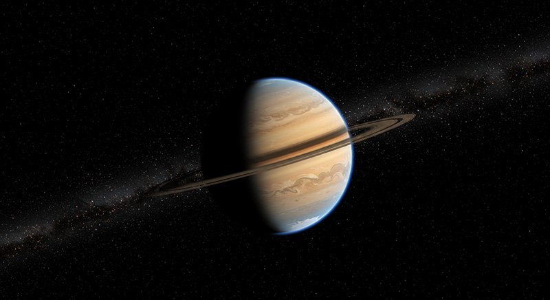 An illustration of the planet Saturn with its rings, partially lit and set against a backdrop of stars and a faint section of the Milky Way.