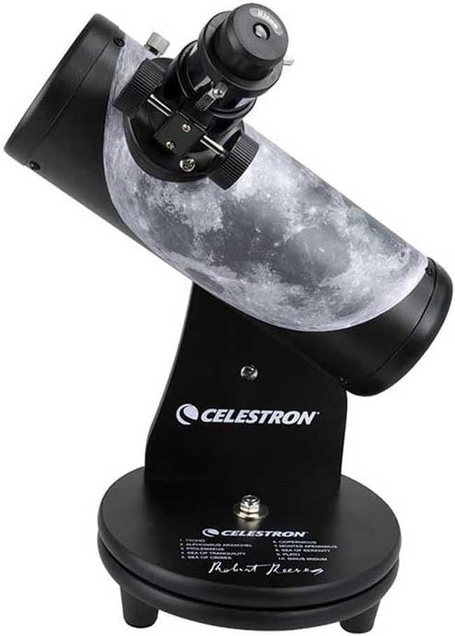 A tabletop Celestron telescope with a moon graphic on its tube, mounted on a black base with the Celestron logo and Robert Reeves' signature.