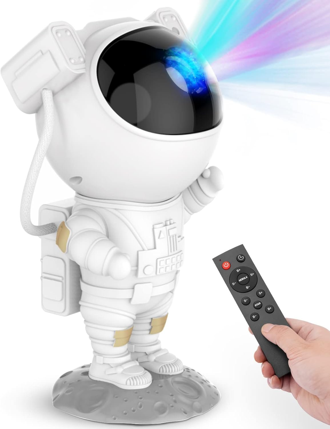A hand holds a remote control pointed at a small astronaut figurine, which is projecting colorful lights from its helmet.
