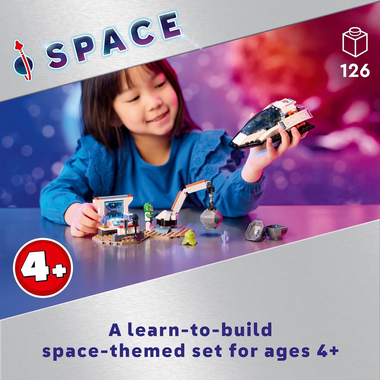 Young child playing with a space-themed building set, which includes a small spaceship, robotic arm, and accessories, for ages 4 and up.
