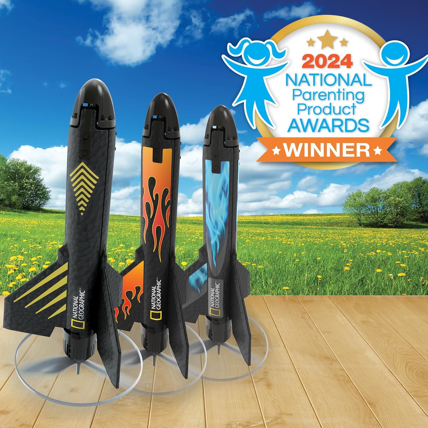 Three model rockets with different designs stand on a wooden surface outdoors, next to a "2024 National Parenting Product Awards Winner" badge.