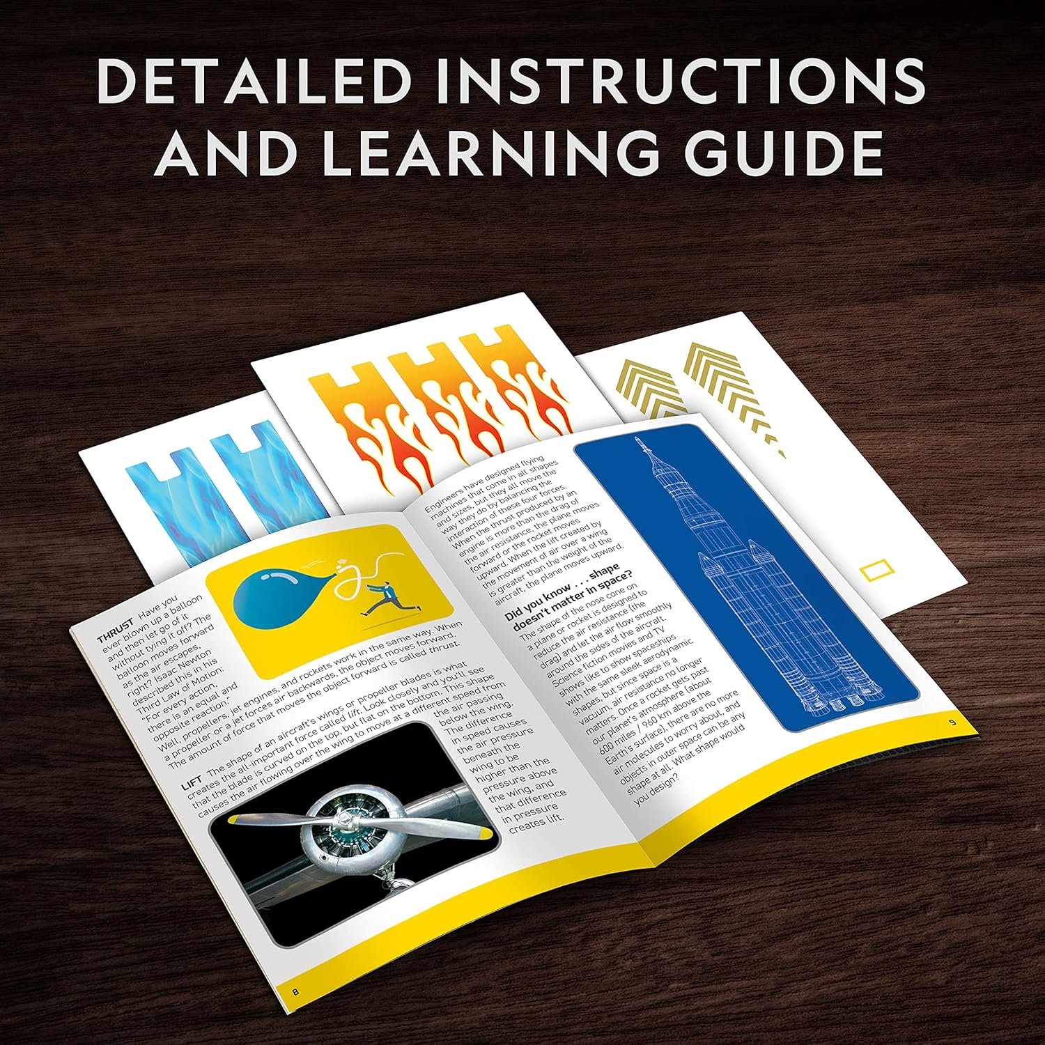 An open booklet with illustrated instructions and diagrams lies on a wooden surface, surrounded by colorful cut-out sheets. Text above reads: "DETAILED INSTRUCTIONS AND LEARNING GUIDE.