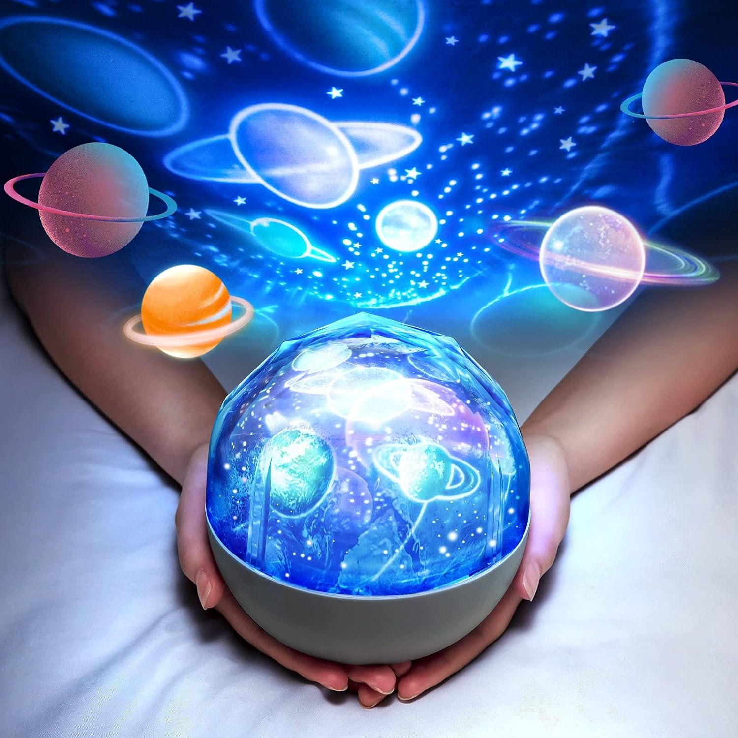 A person holds a glowing spherical projector that displays an array of colorful planets and stars onto a nearby surface.