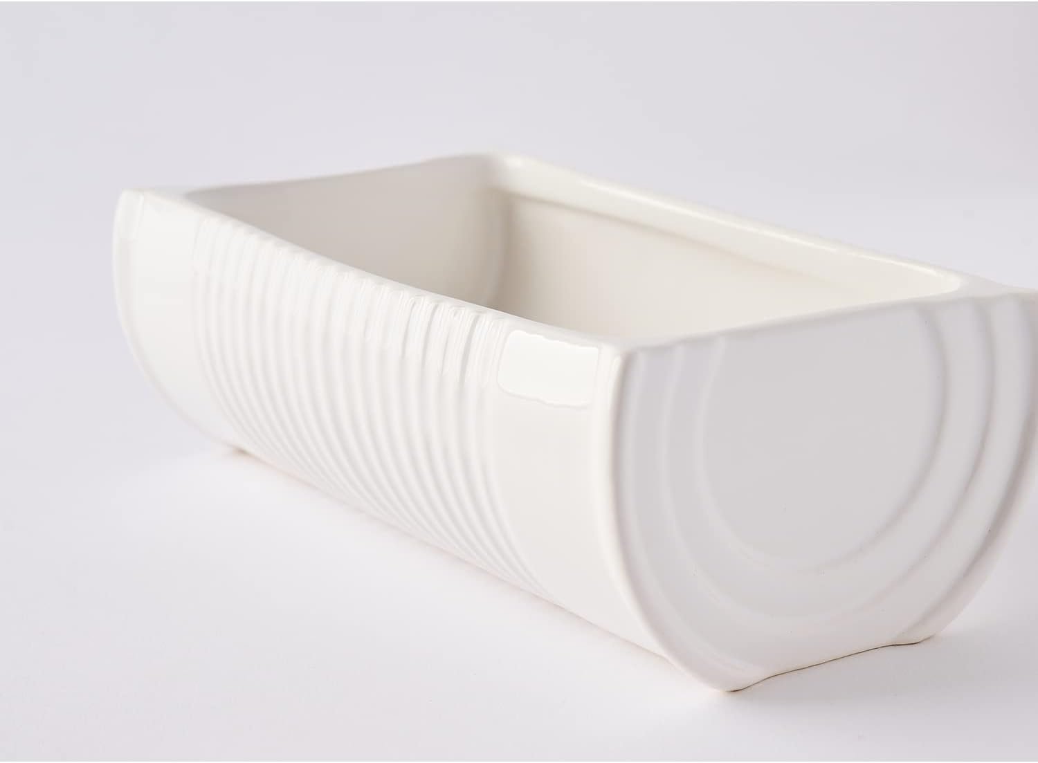 A white rectangular ceramic dish with ribbed sides and rounded corners, photographed on a plain white background.