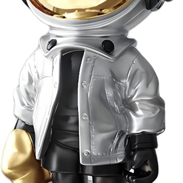 A stylized astronaut figurine with a shiny gold helmet, oversized boots, a silver jacket, and holding a small gold object in its left hand.