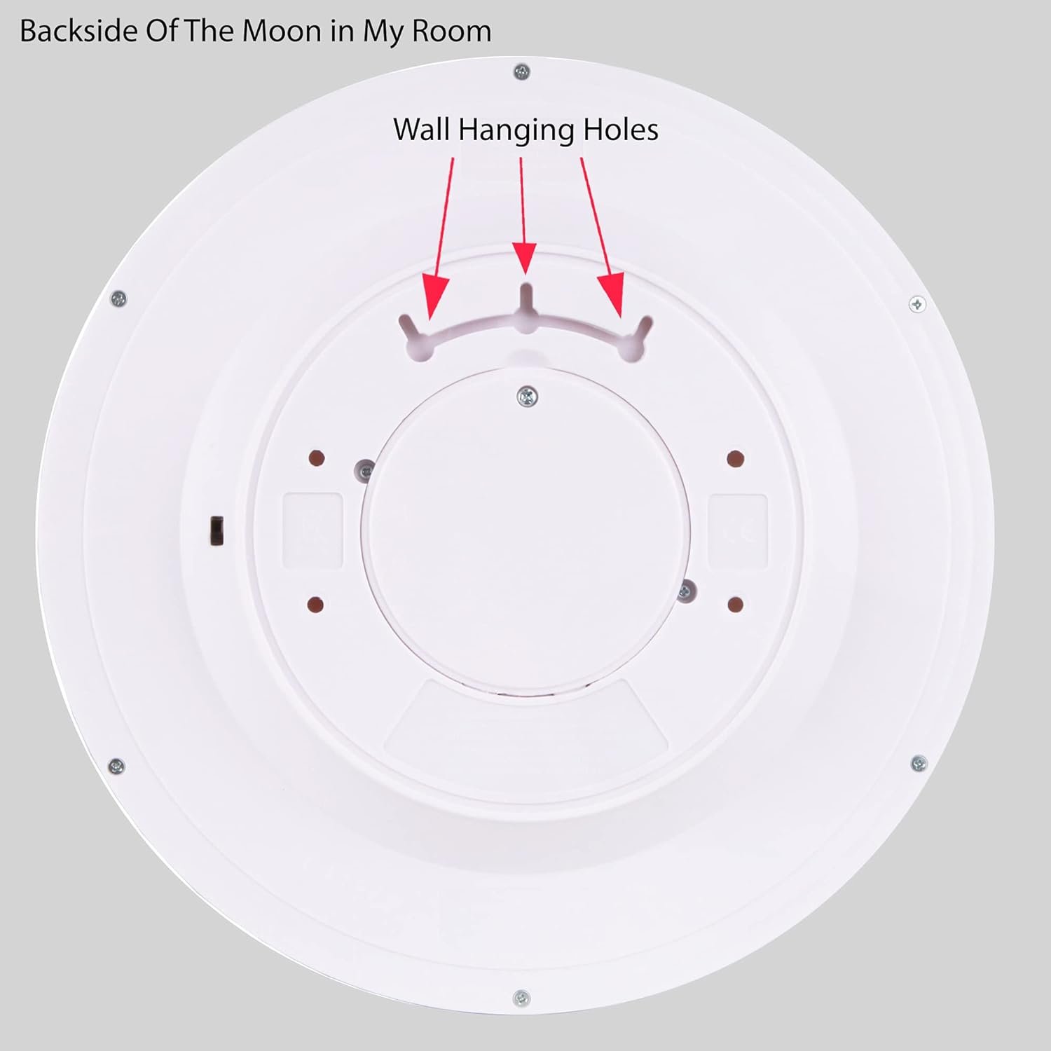 Round white object labeled "Backside Of The Moon in My Room" with arrows pointing to wall hanging holes.
