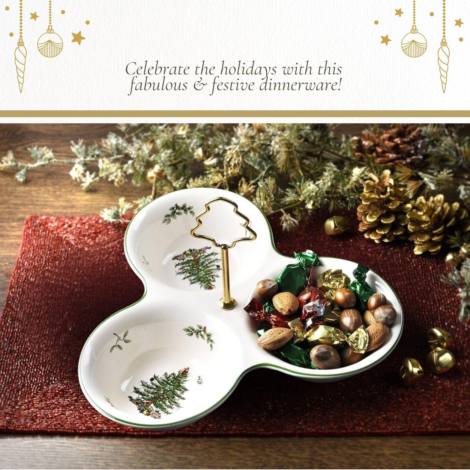 A festive ceramic serving tray with a gold tree handle holds assorted candies and nuts, placed on a red placemat with pinecones and holiday greenery in the background.