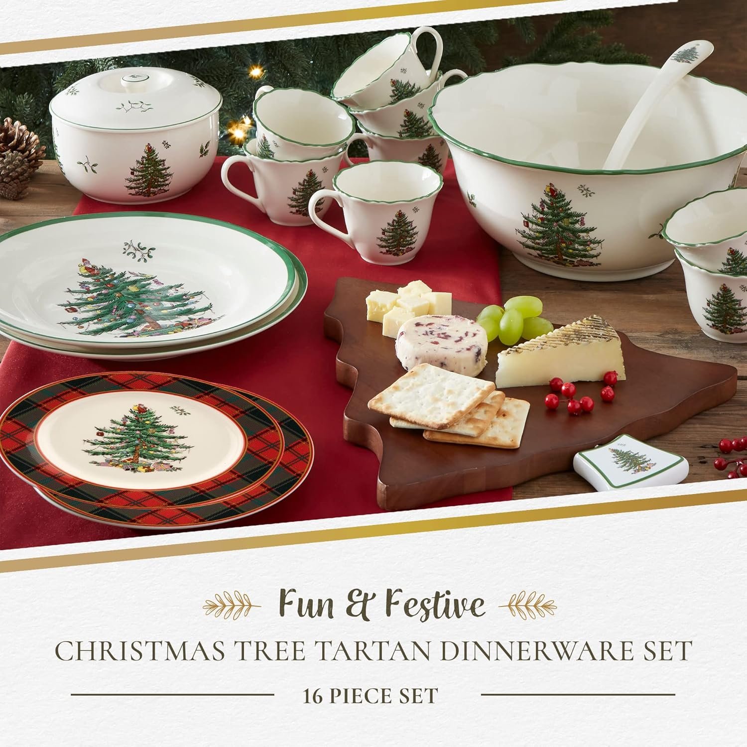 A 16-piece Christmas tree tartan dinnerware set with plates, bowls, cups, and a serving board arranged on a red tablecloth with cheese, crackers, and grapes.
