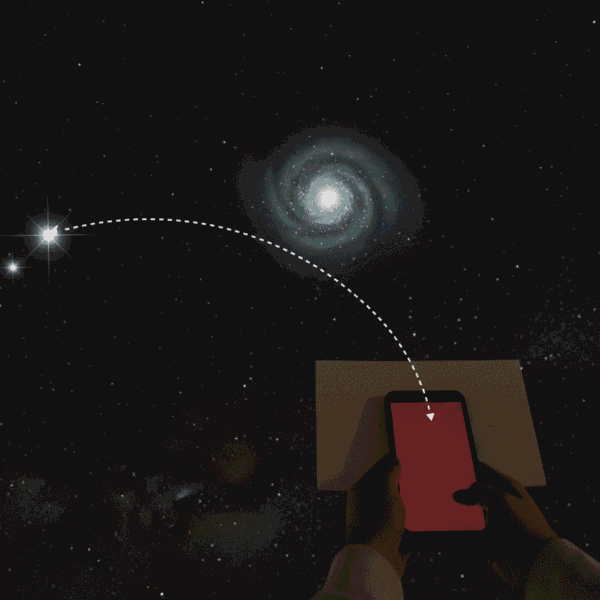 Hands hold a smartphone pointed at the night sky, with a dotted line connecting stars and a distant galaxy above to the device, suggesting data or signal transfer across the sky.
