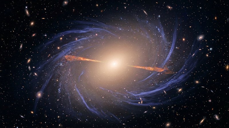 A bright galaxy at the center emits light, with spiral arms and numerous smaller galaxies, red geyser galaxies, and stars scattered throughout the dark space background.